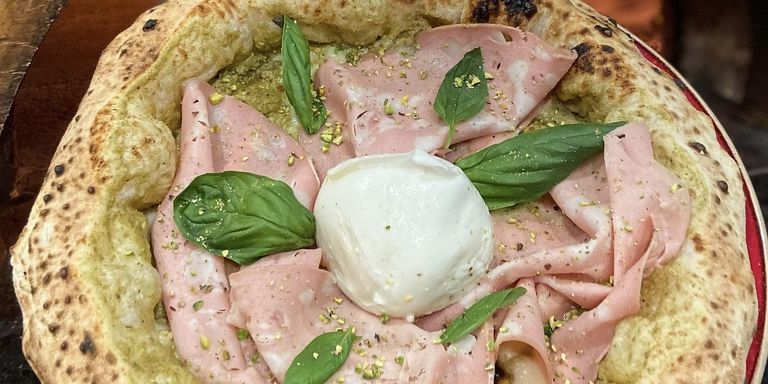 Wood-fired pizza topped with mortadella, burrata and basil