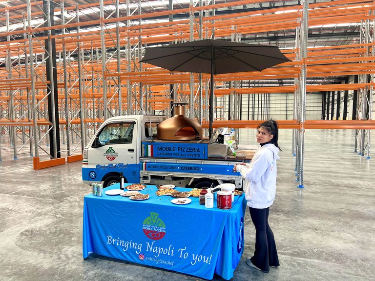 Our blue and white pizza truck with its copper oven, set up inside an Adelaide warehouse for a workplace event