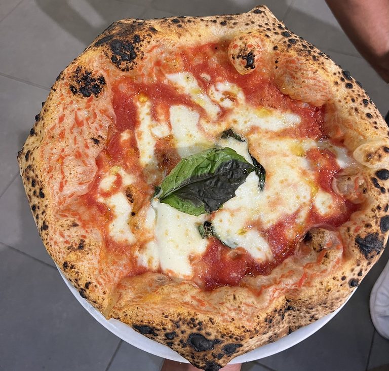 Wood-fired margherita pizza with basil and a charred crust