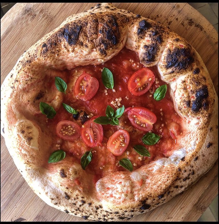 Wood-fired pizza with cherry tomatoes and basil