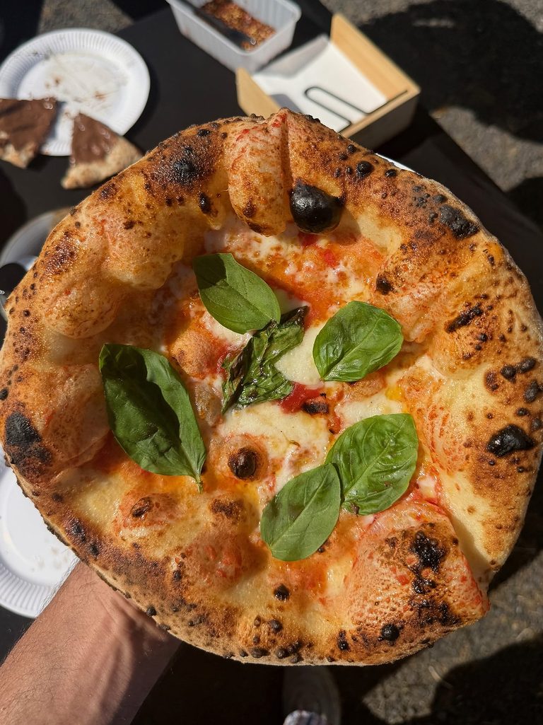 Close-up of a wood-fired Margherita pizza with fresh basil and charred crust, pizza catering Adelaide