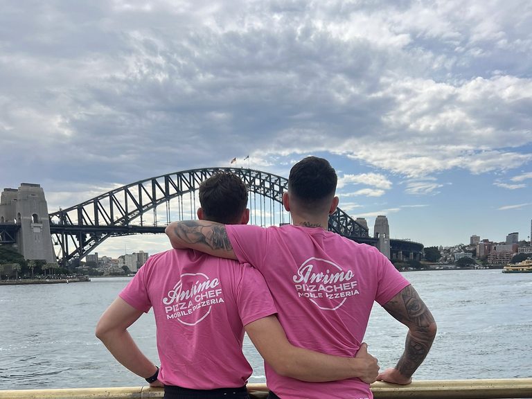 Matteo (Matteo Pizza Singer) and Antimo in pink Antimo Pizza Chef shirts at the Sydney Opera House, looking at the Sydney Harbour Bridge
