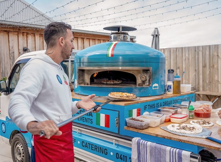 Our chef at the blue pizza truck under festoon lights