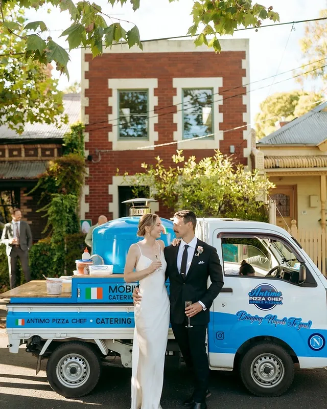 Bride and groom with the blue Antimo Pizza Chef truck