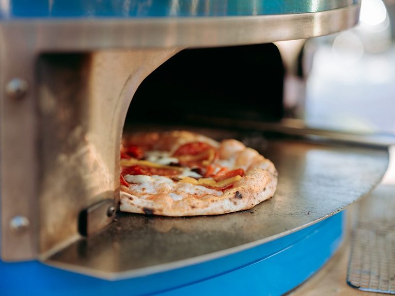 Pizza baking in the wood-fired oven, pizza catering Salisbury
