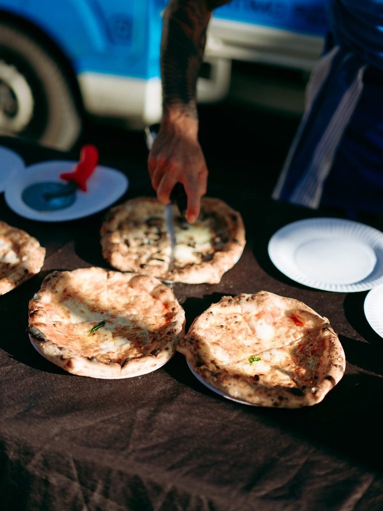 Chef serving fresh pizzas to guests, pizza catering Sutherland Shire