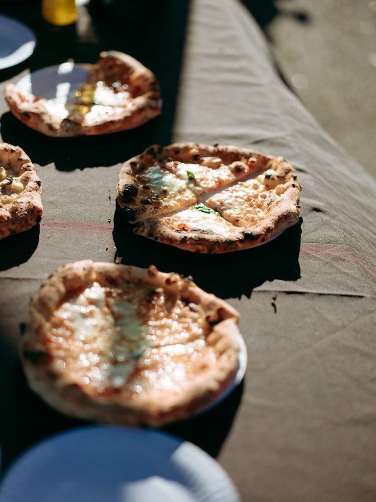 Fresh wood-fired pizzas on the serving table